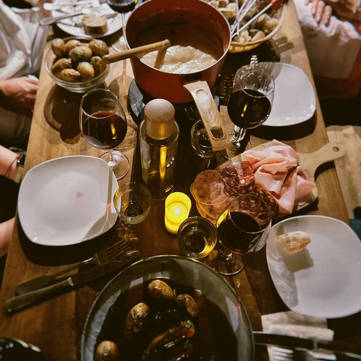 Une tablée en cours de service autour du caquelon de fondue