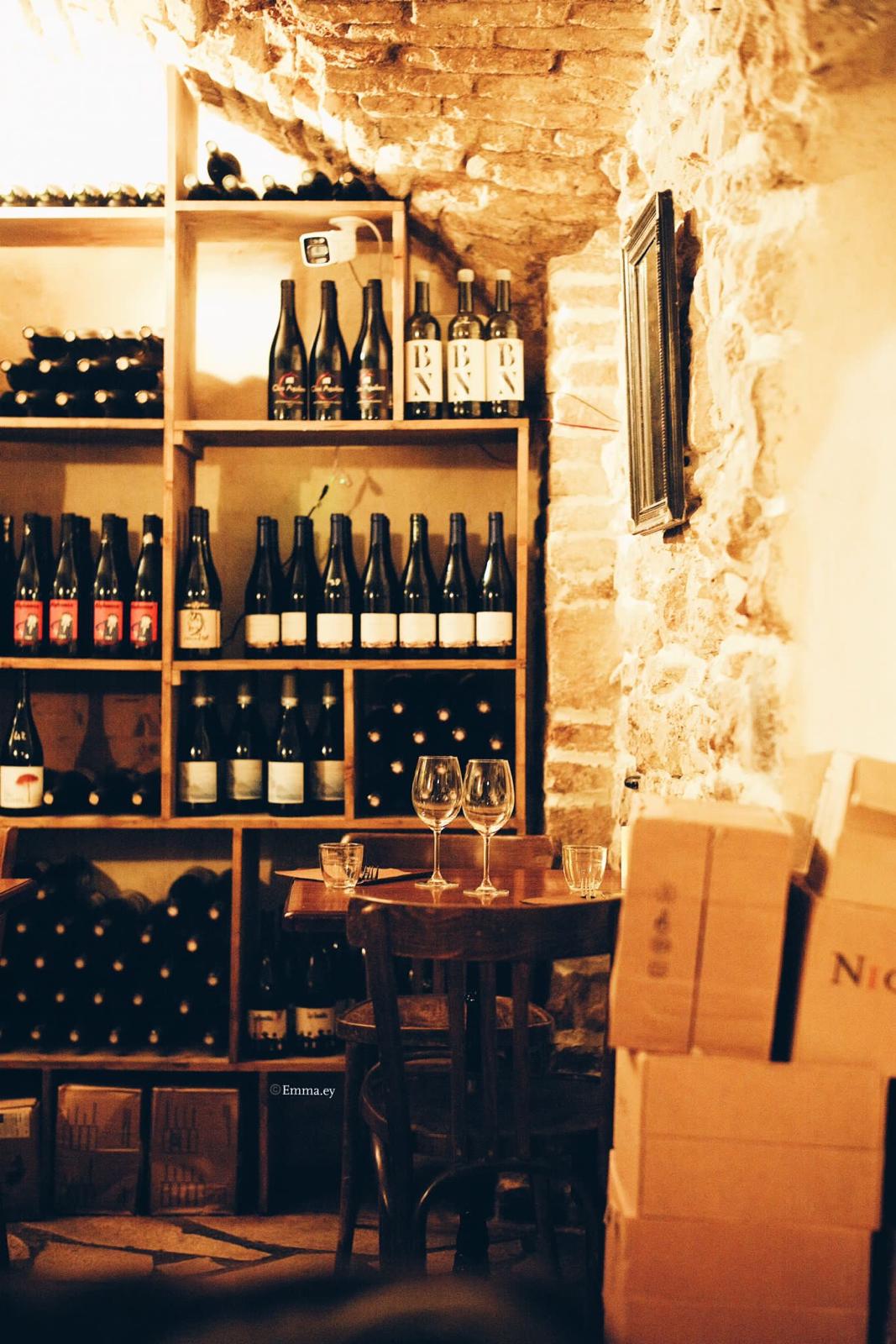 Coin cave à vins naturels sous la voûte, petite table dressée pour deux