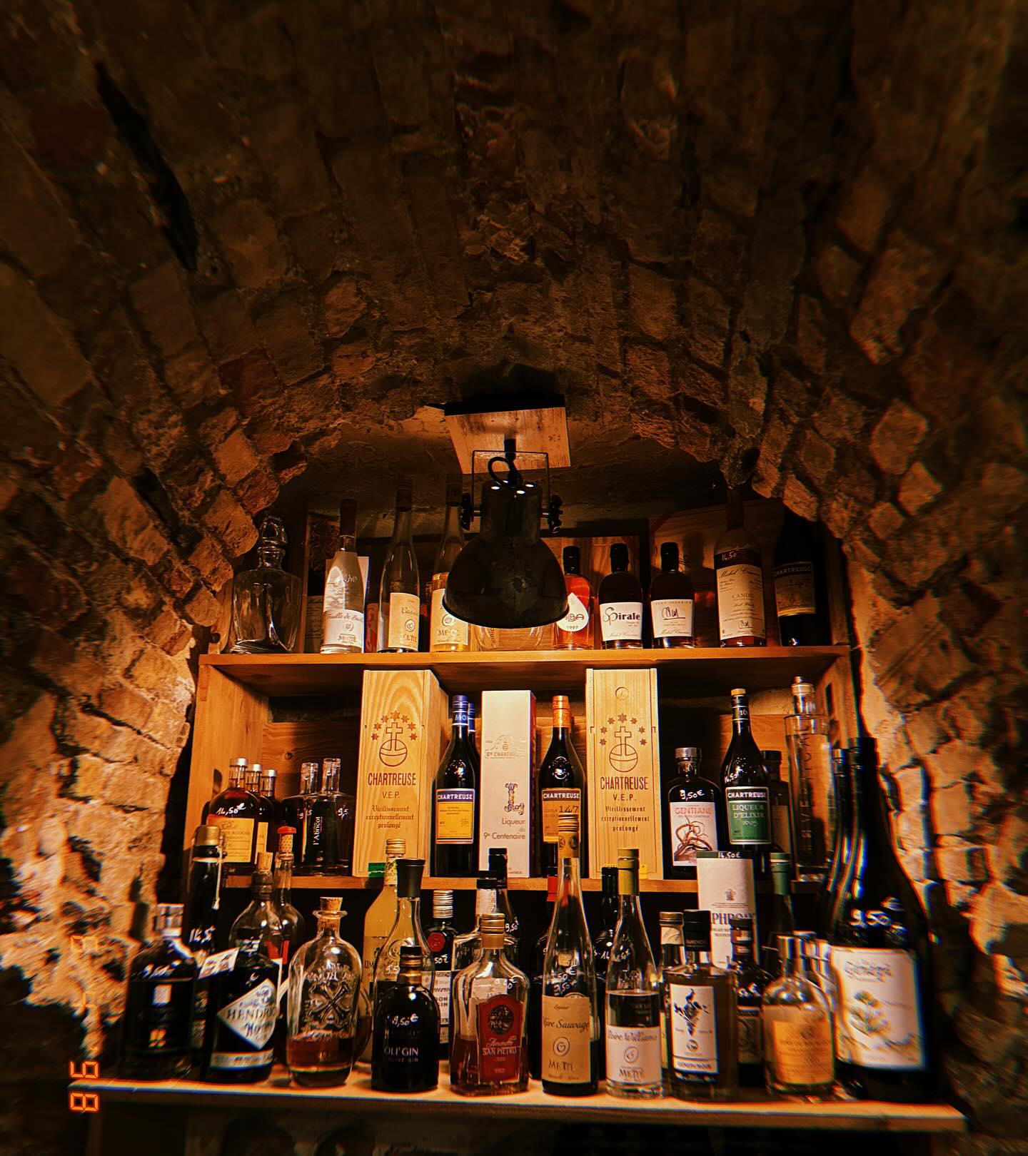 Sous l'arche, le mur de bouteilles — La Cave du Fromager, Vieux-Nice