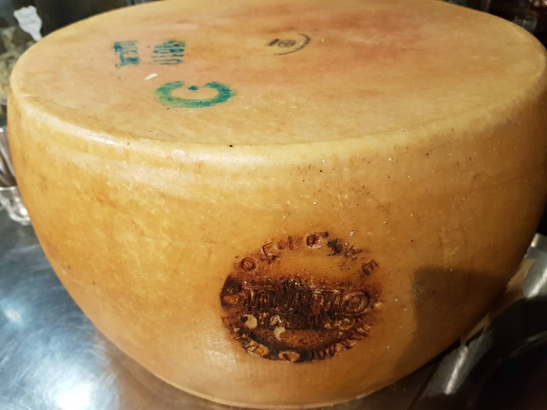 Meule de parmesan entière au comptoir de la cave